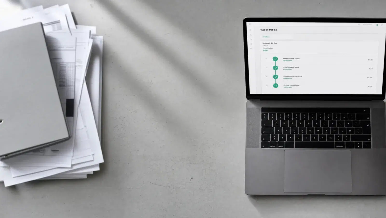 Documentos impresos apartados junto a un portátil que muestra el mismo circuito de aprobación completado automáticamente